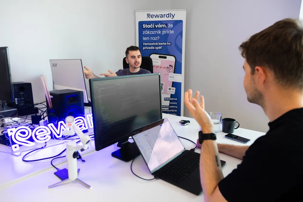 Two Rewardly teammates talking through a problem at their desks
